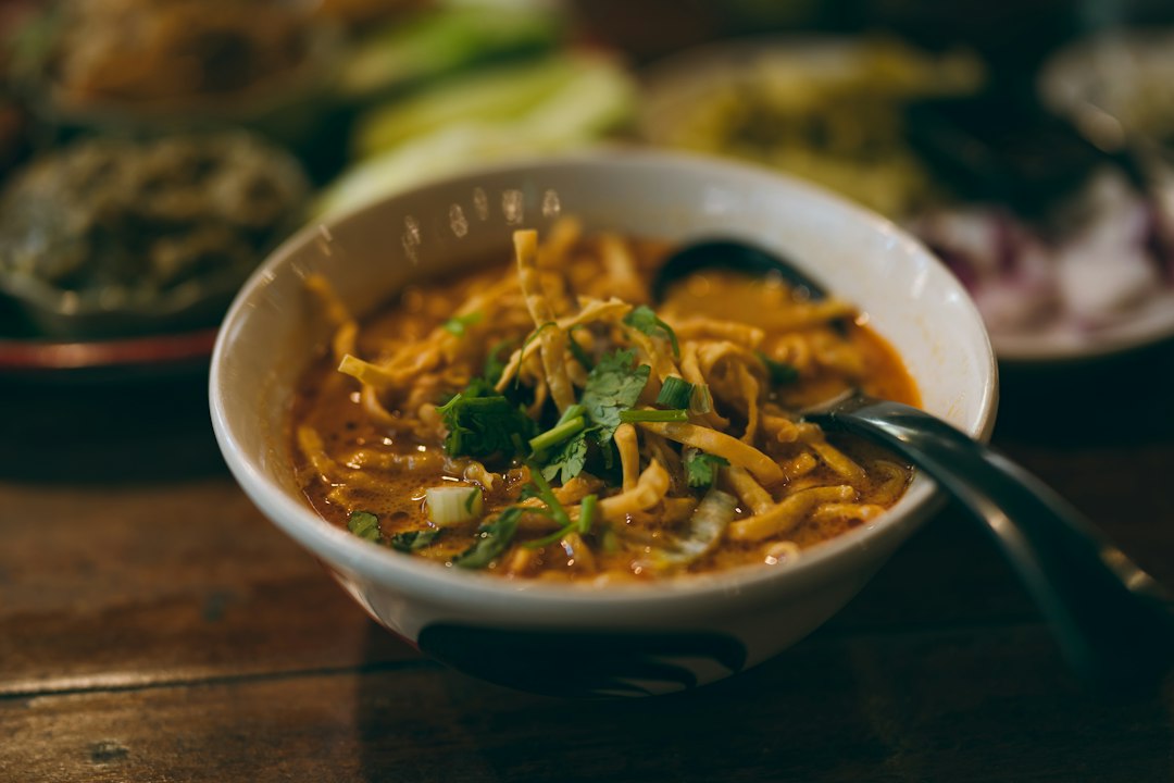 Khao Soi mit weichen und knusprigen Nudeln in einer Schale