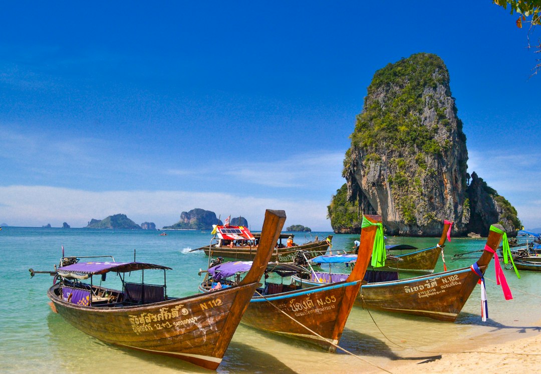 Longtail-Boote liegen vor einer tropischen Küste in Thailand