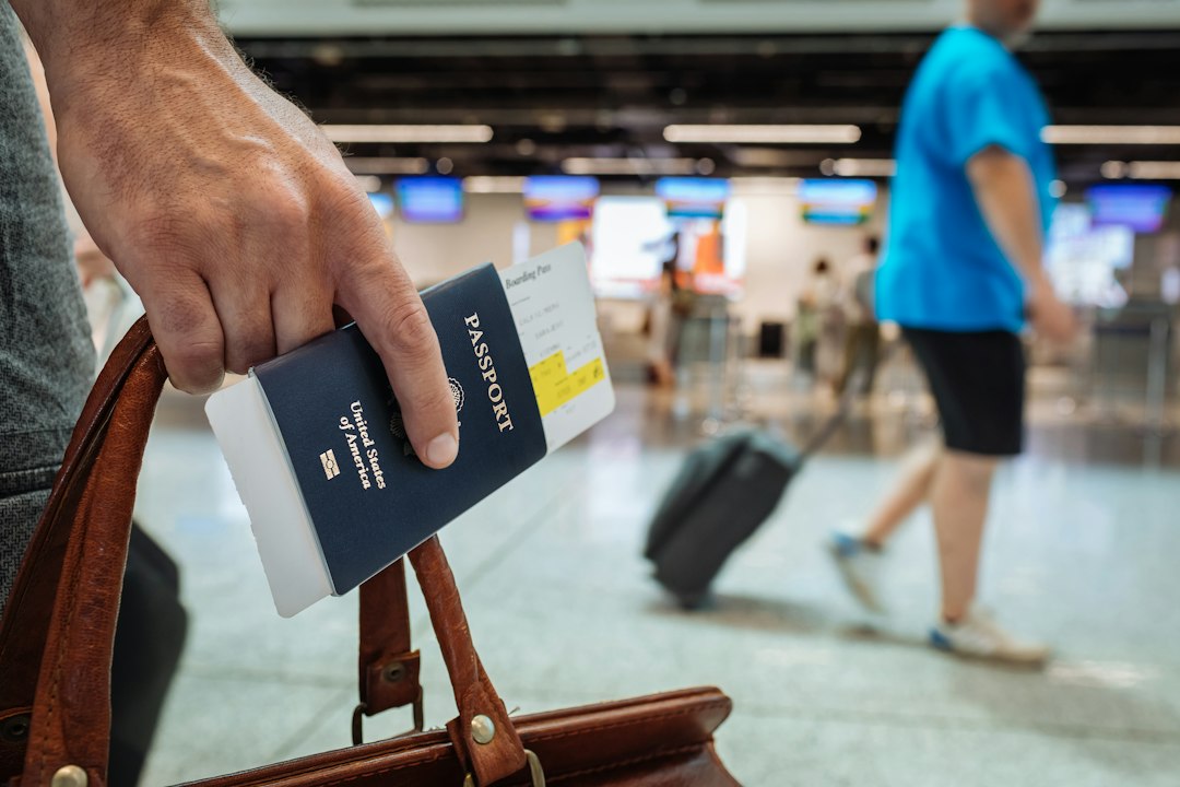 Eine Hand hält ein Reisedokument als Symbol für die Reisevorbereitung